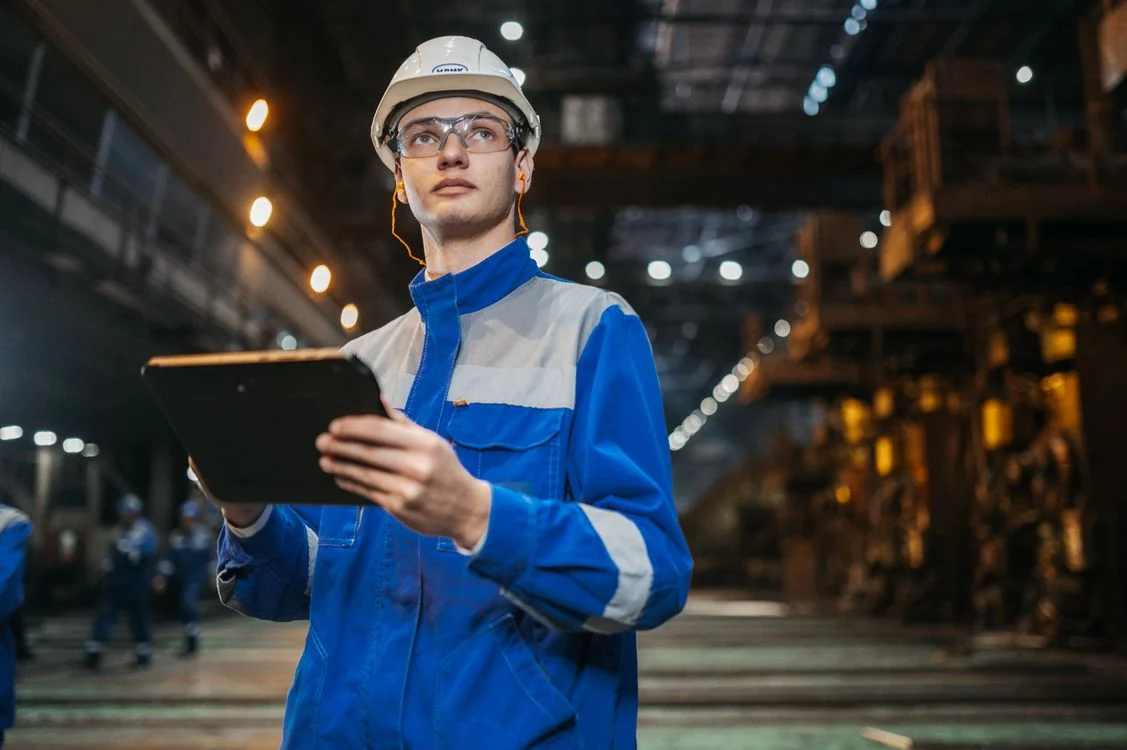 Ingenieur met een tablet op de werkvloer van een metaalfabriek